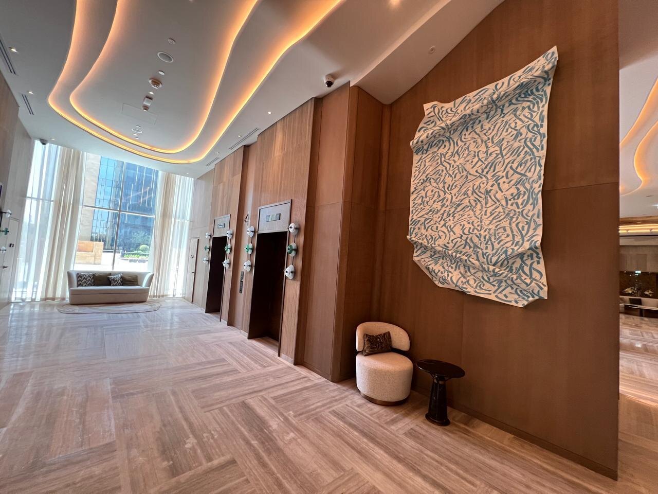 Executive lobby with timber panels, stone flooring and illuminated ceiling